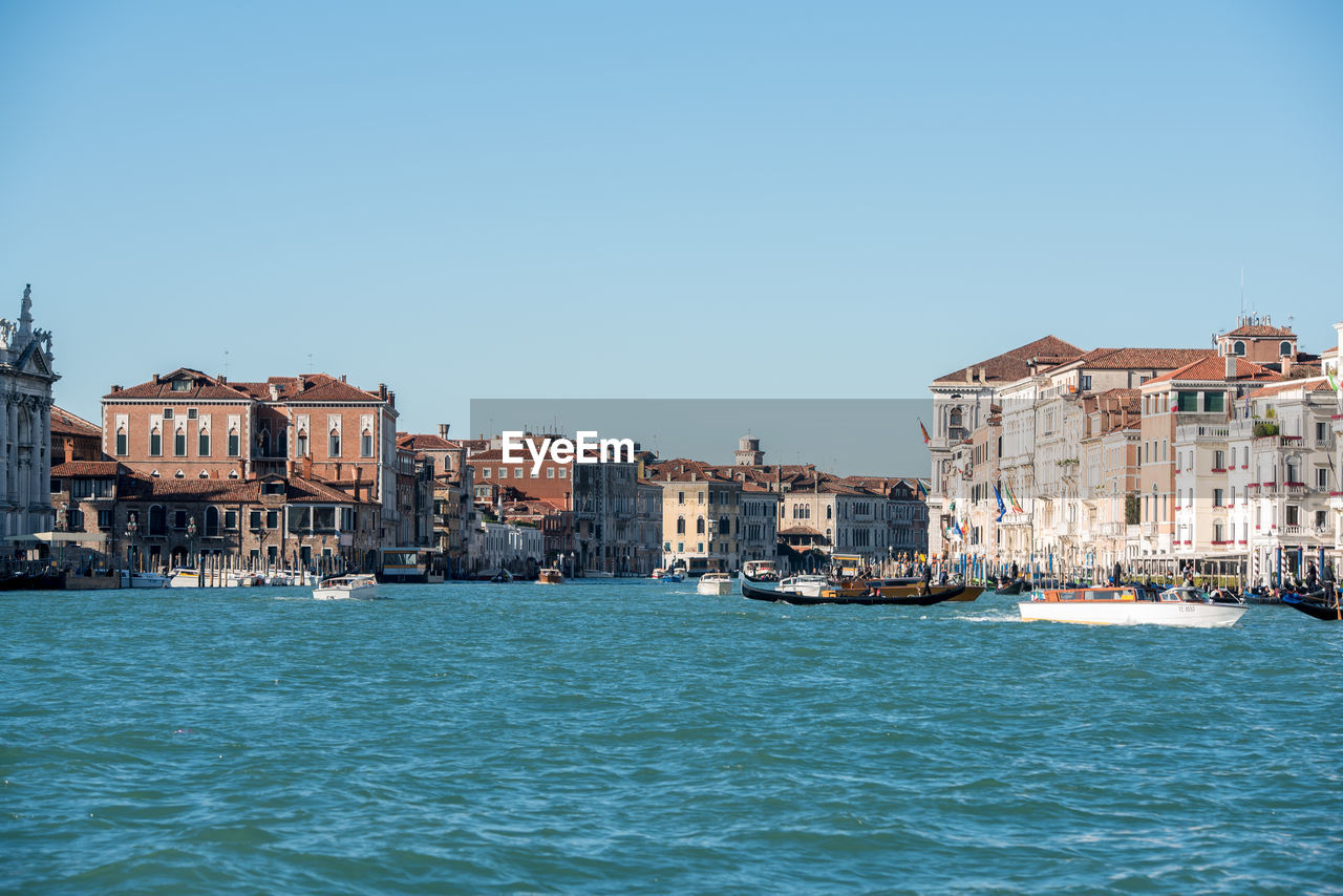 CANAL BY BUILDINGS AGAINST CLEAR SKY