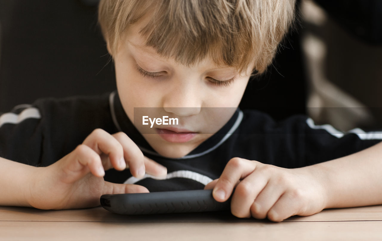 Boy playing on cell phone, sweden