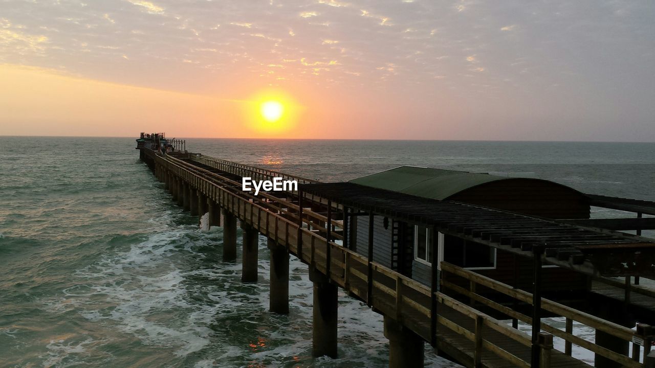 PIER OVER SEA AGAINST SKY DURING SUNSET