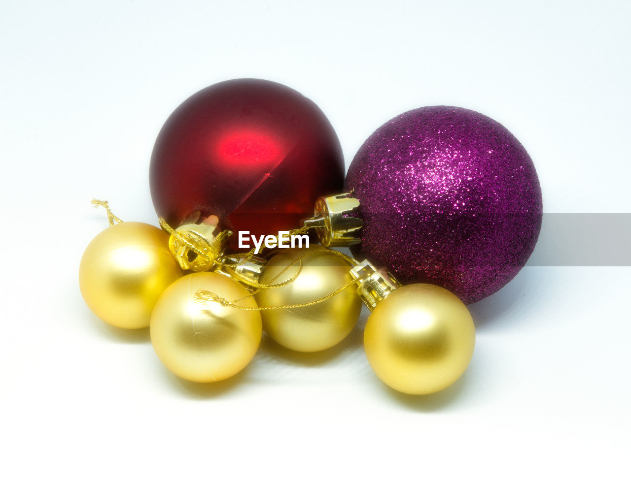 Close-up of multi colored christmas balls against white background