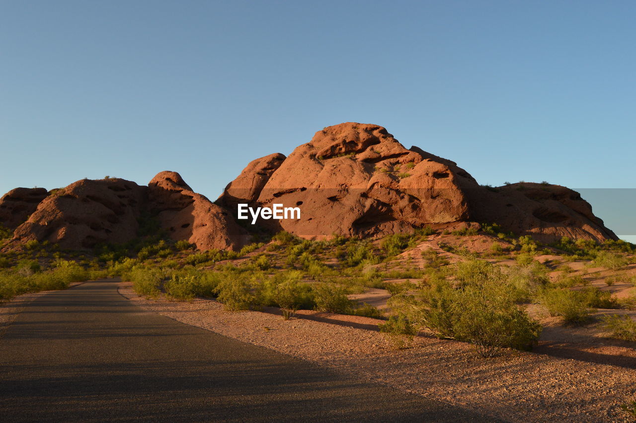 Road amidst desert against clear sky