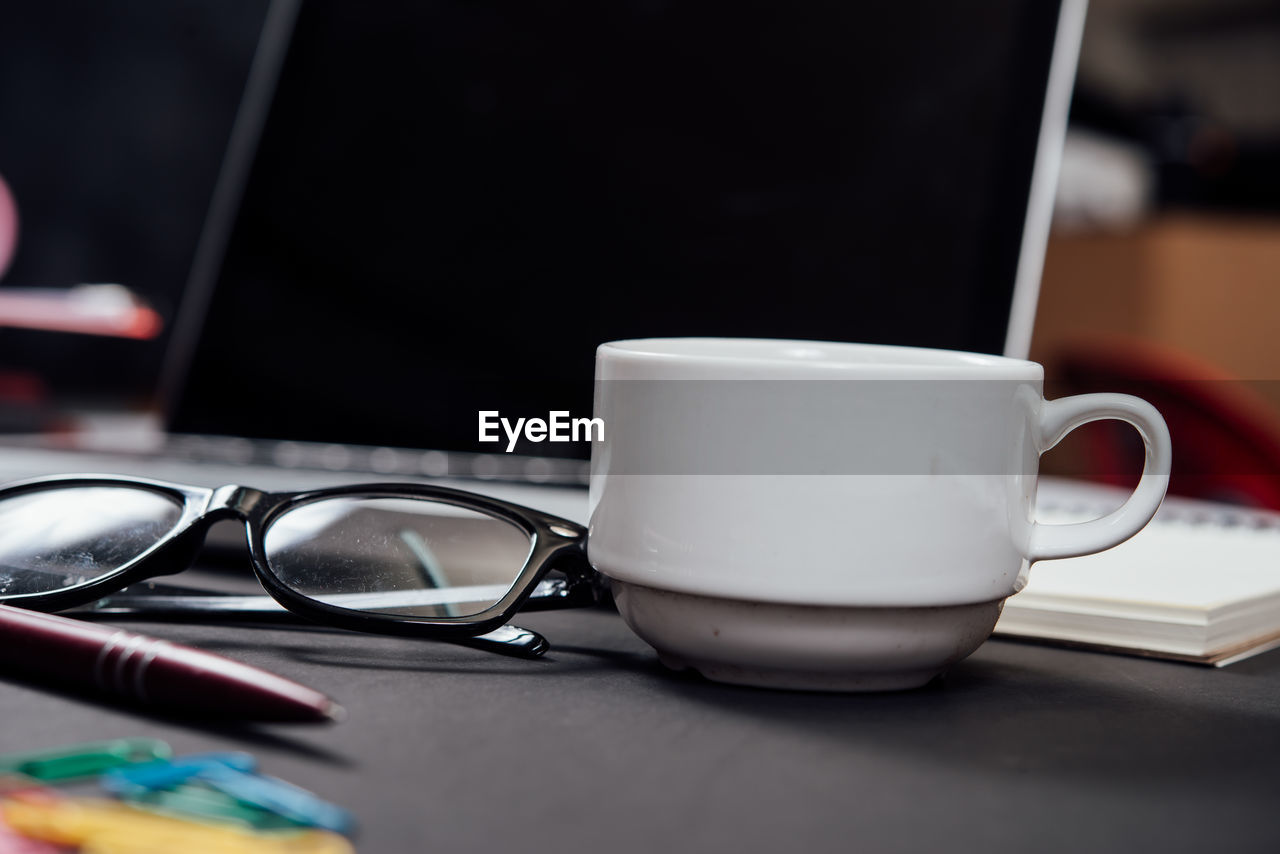 CLOSE-UP OF COFFEE CUP AND TABLE