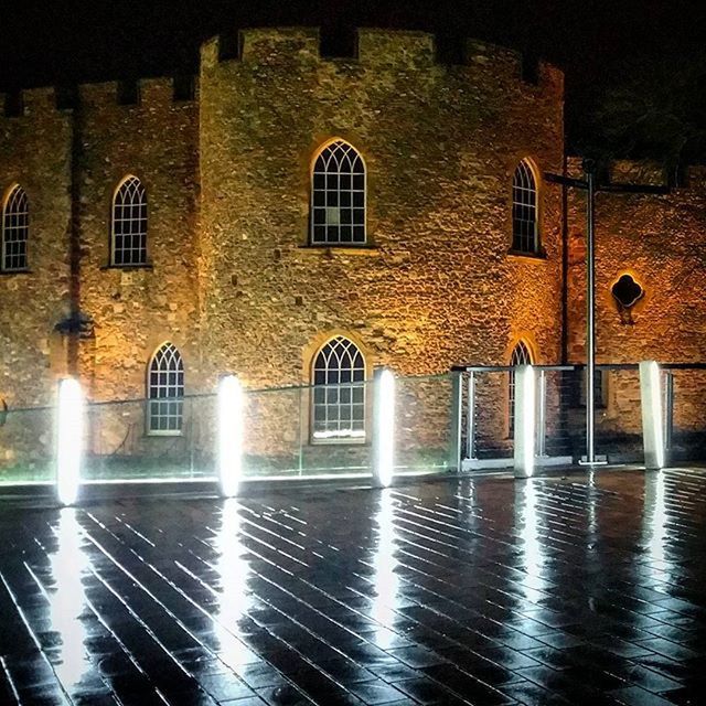 REFLECTION OF ILLUMINATED BUILT STRUCTURE IN WATER