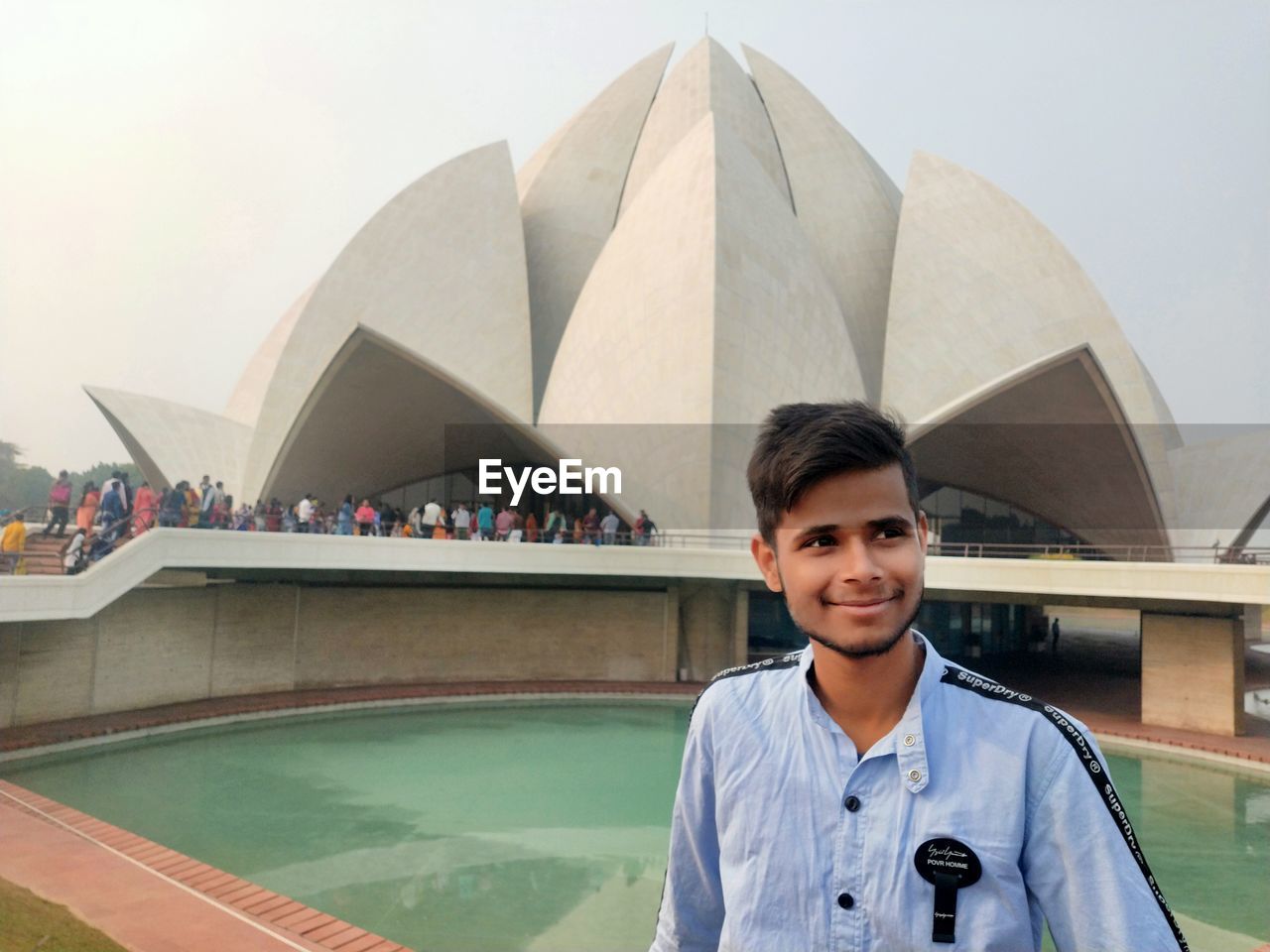 Smiling young man standing against built structure