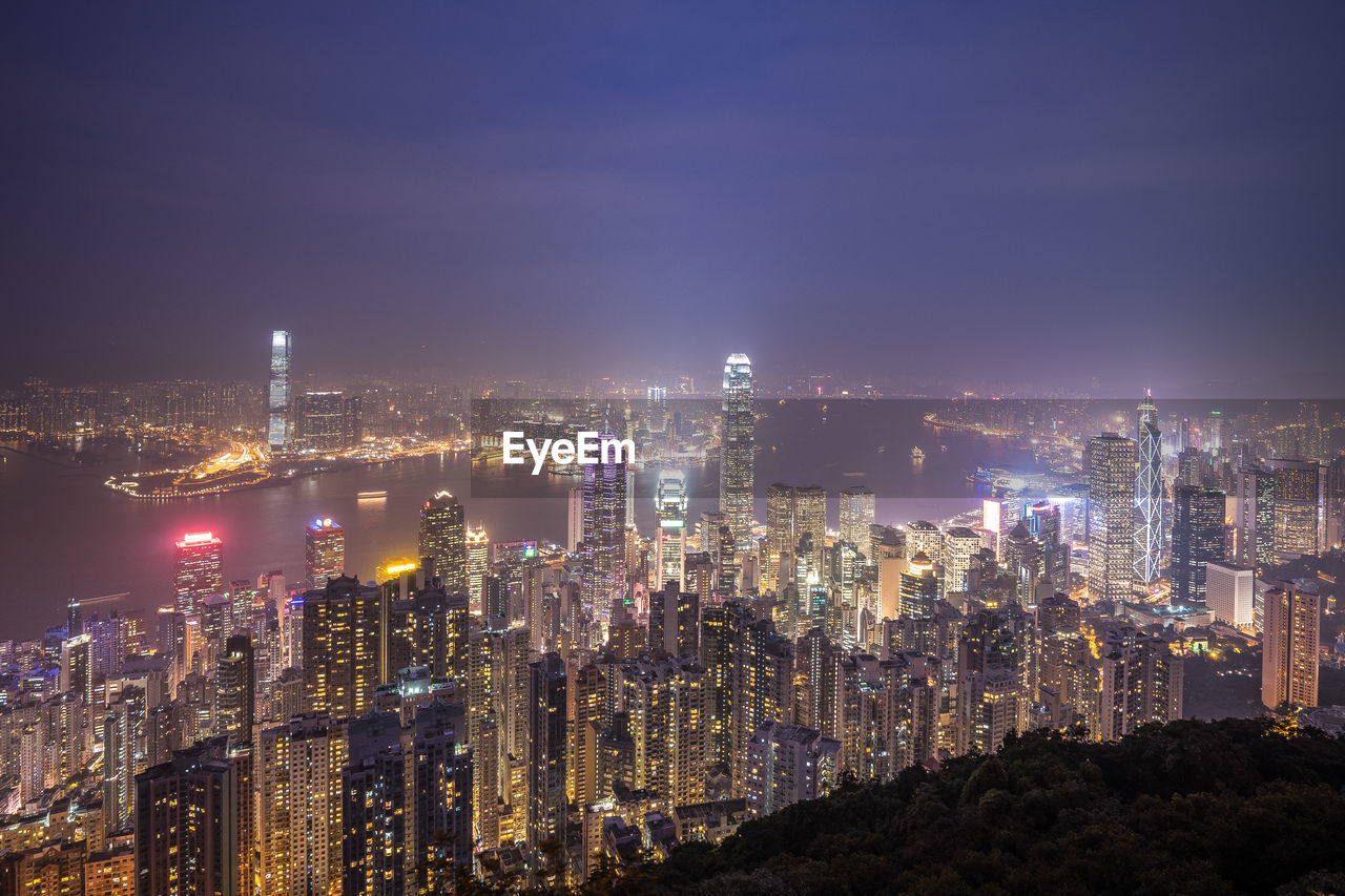 Illuminated cityscape against sky at night