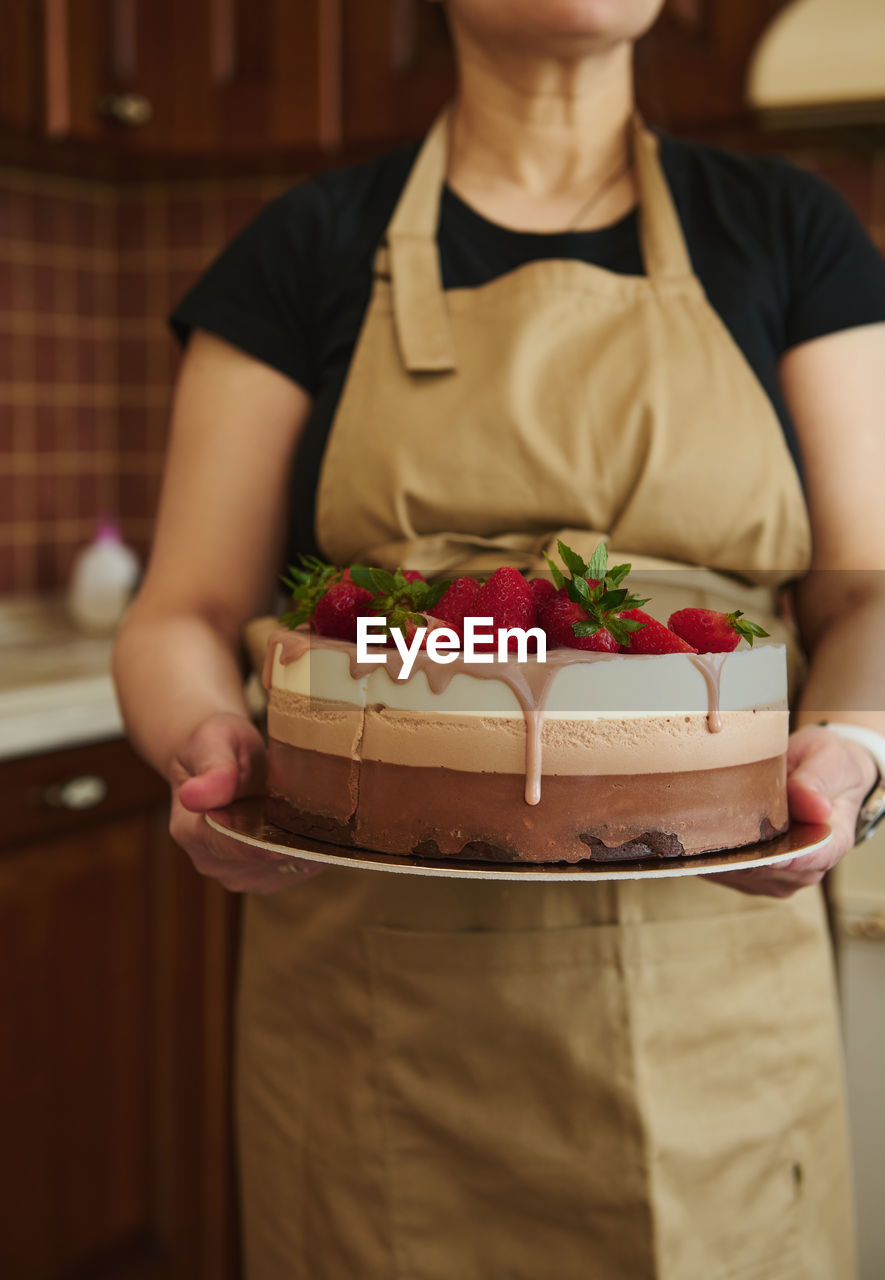 midsection of woman holding cake