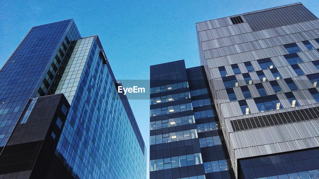 LOW ANGLE VIEW OF SKYSCRAPERS AGAINST BLUE SKY