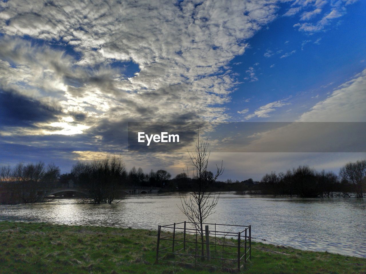 SCENIC VIEW OF LAKE AGAINST CLOUDY SKY