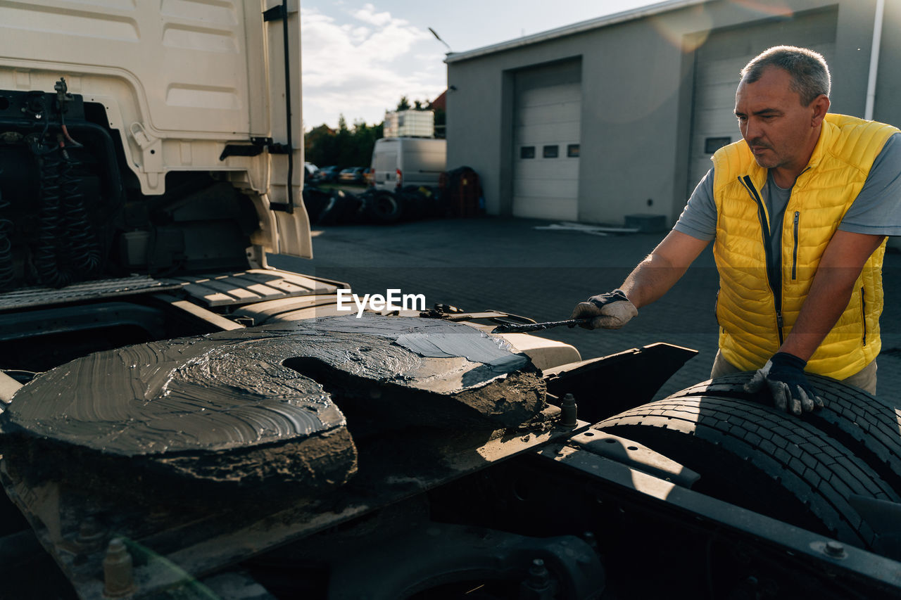 side view of man standing by car