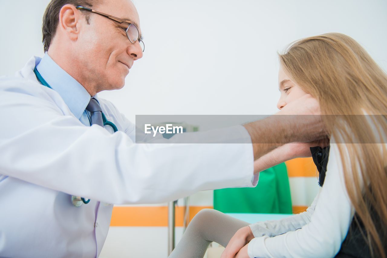 Side view of doctor examining girl in hospital