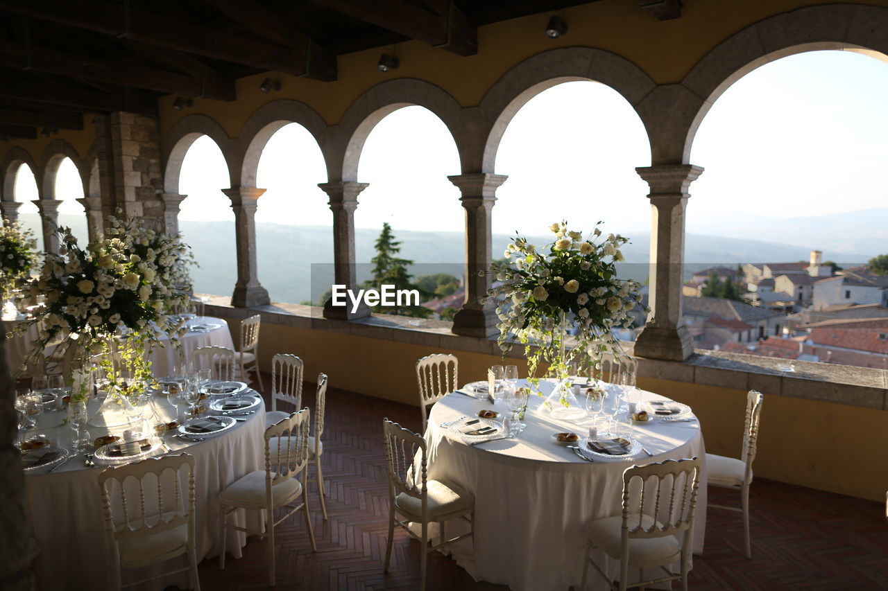 Chairs and tables in restaurant by building