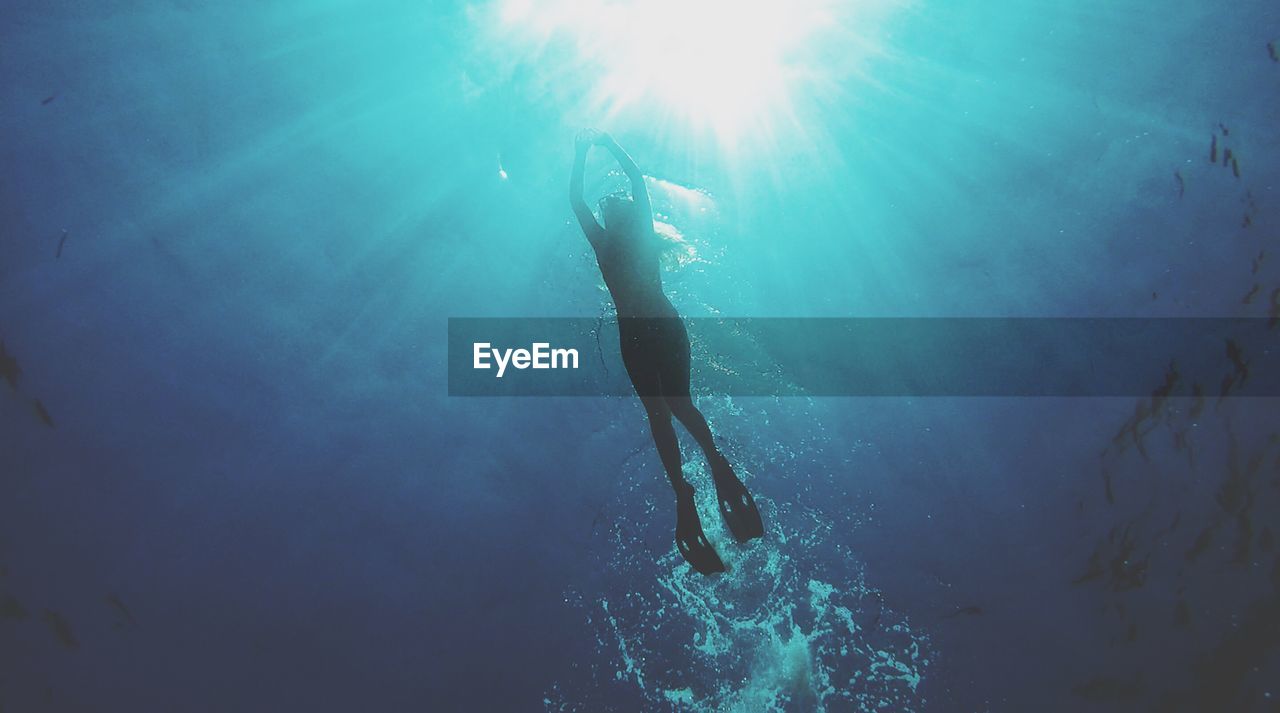 Low angle view of woman scuba diving in sea