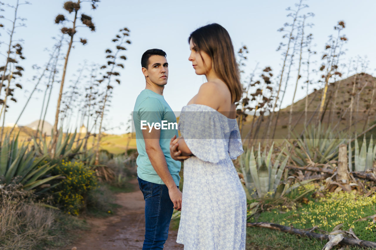 Man standing by woman on footpath