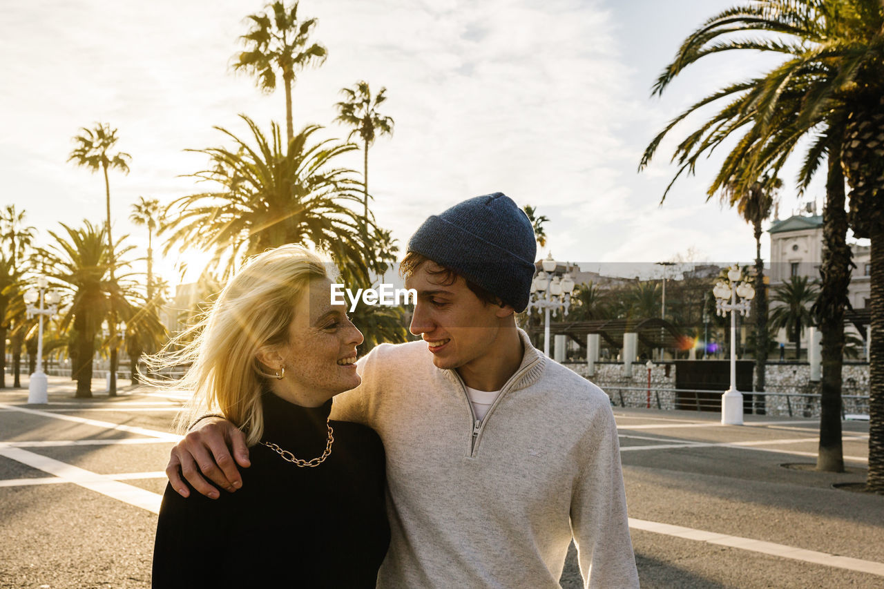 Smiling young couple at promenade during sunny day