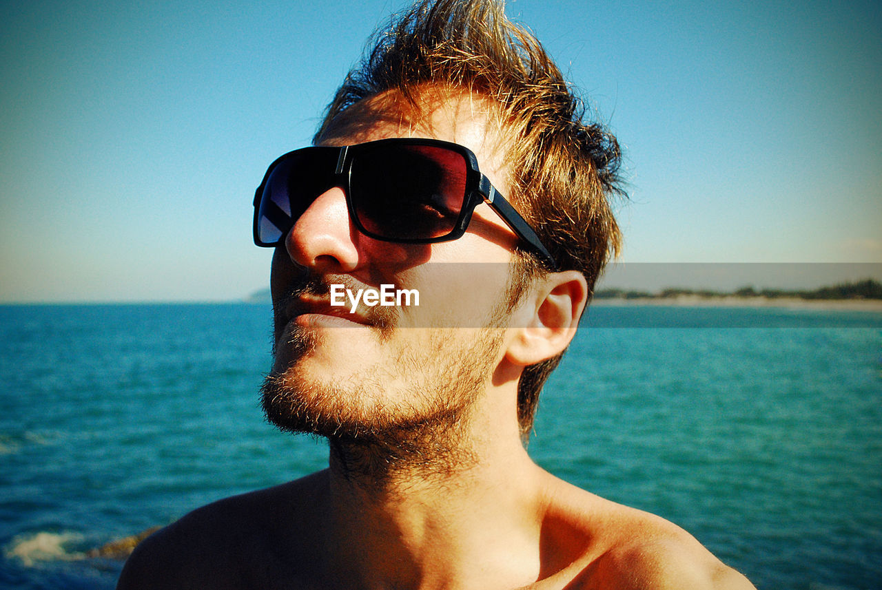 PORTRAIT OF YOUNG MAN WEARING SUNGLASSES