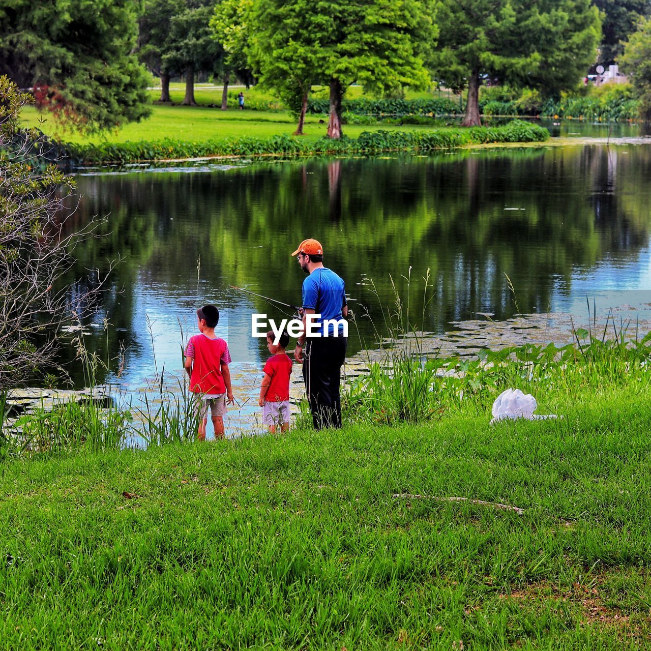 MEN WITH ARMS RAISED ON LAKE