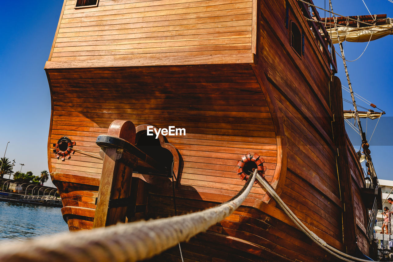 LOW ANGLE VIEW OF SAILBOAT IN SEA AGAINST BUILDING