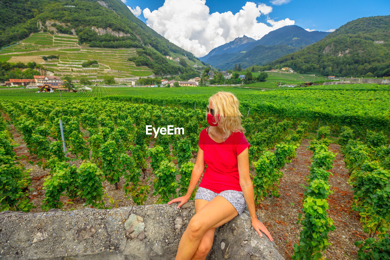 Beautiful woman wearing mask sitting at farm