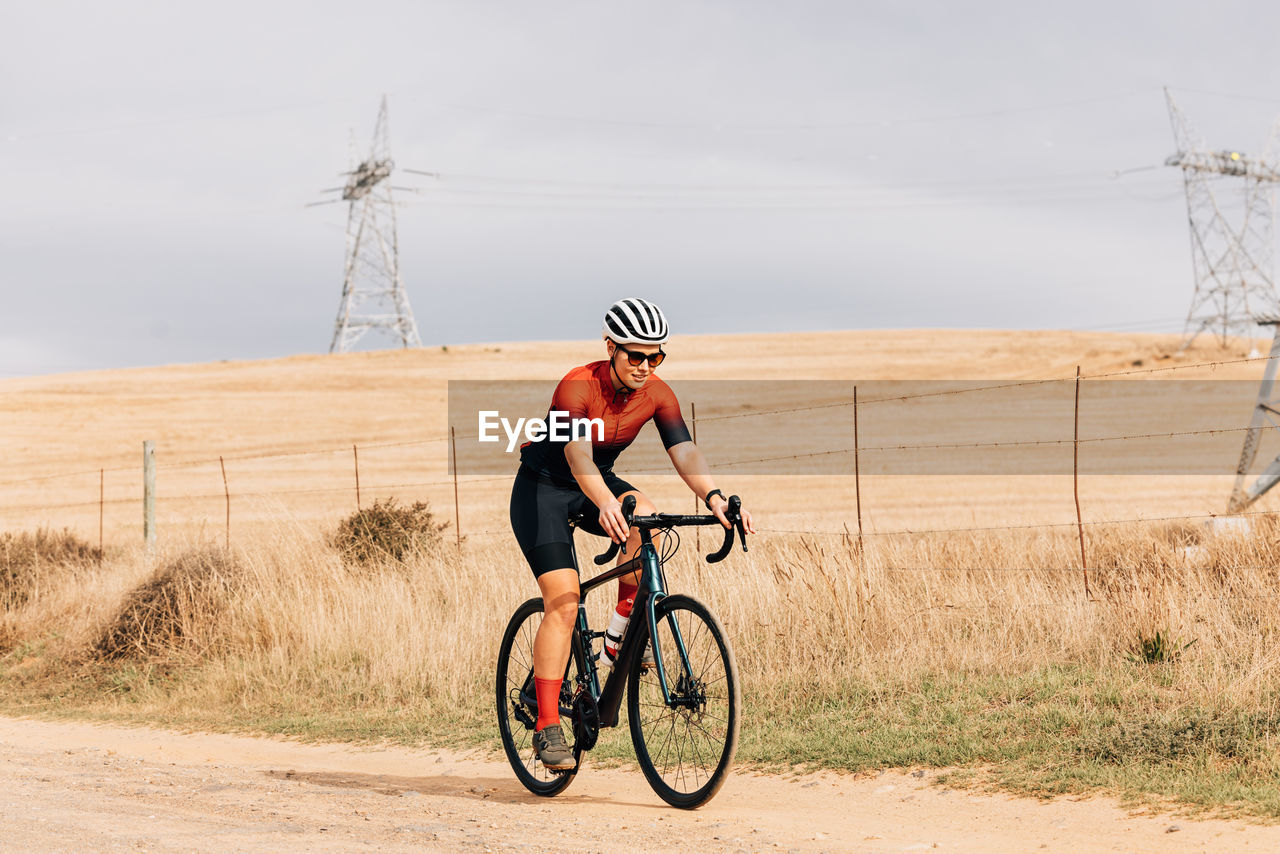 Woman cycling on dirt road