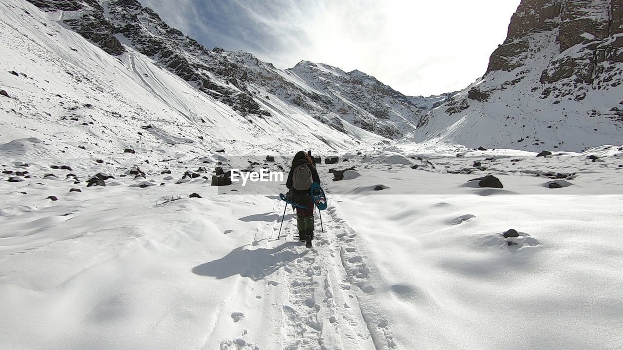MAN SKIING ON SNOWCAPPED MOUNTAINS