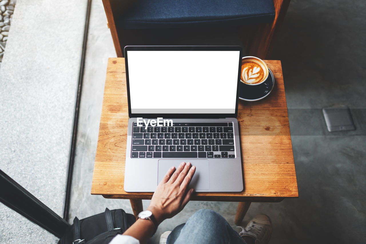 HIGH ANGLE VIEW OF MAN USING LAPTOP