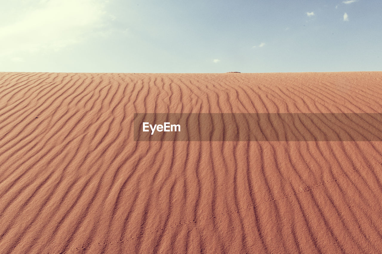 Sand dune in desert against sky