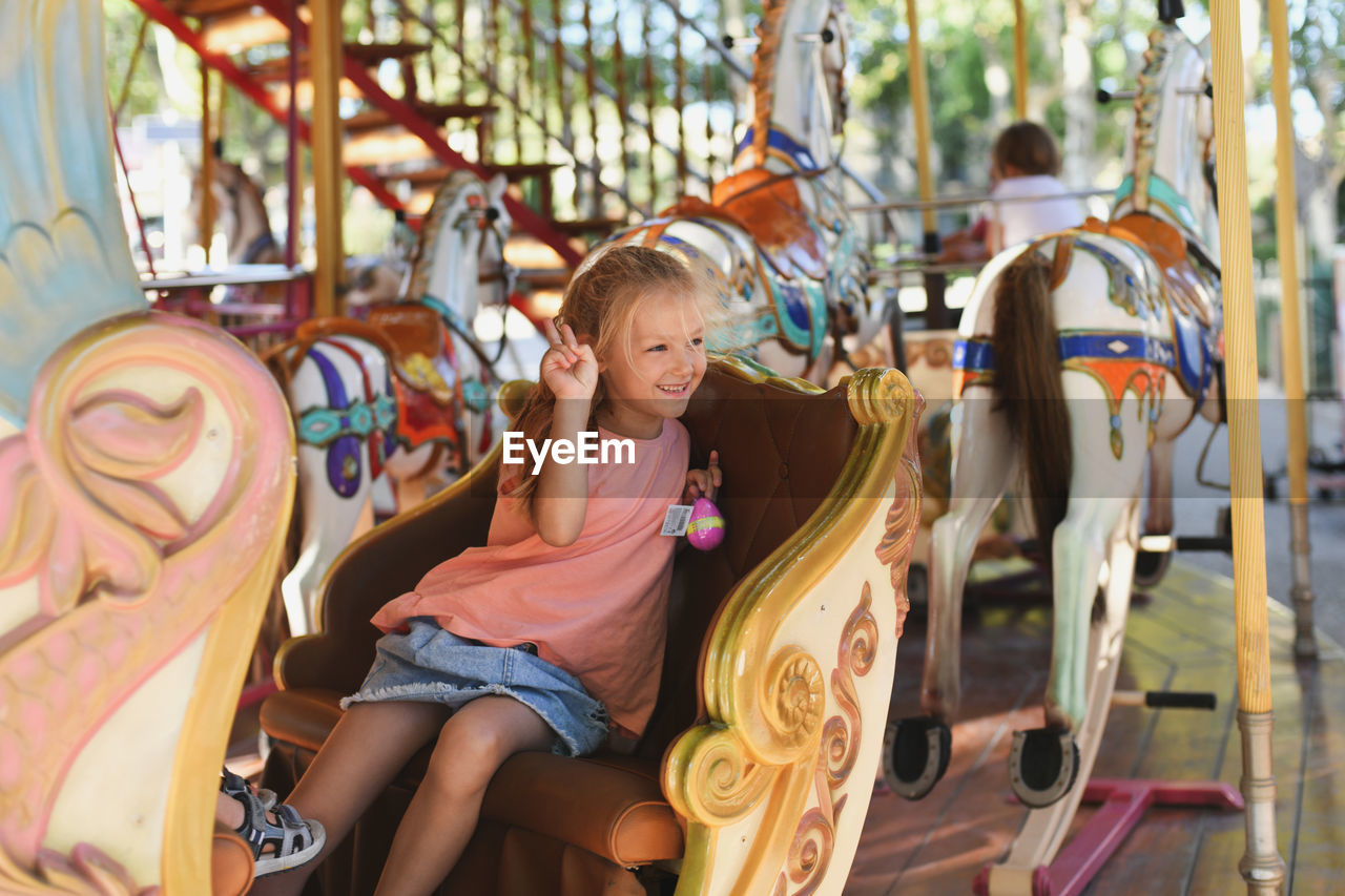 Girl on the carousel. horses on a carnival merry go round