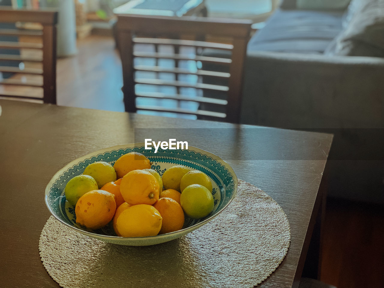 food and drink, food, healthy eating, wellbeing, fruit, citrus, table, freshness, indoors, yellow, citrus fruit, produce, domestic room, no people, furniture, bowl, focus on foreground, home interior, still life, chair, seat, plant, wood, day, high angle view, domestic life, home, clementine, lemon, container