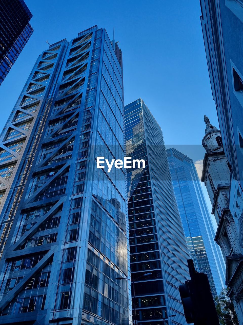 Low angle view of modern buildings against clear blue sky