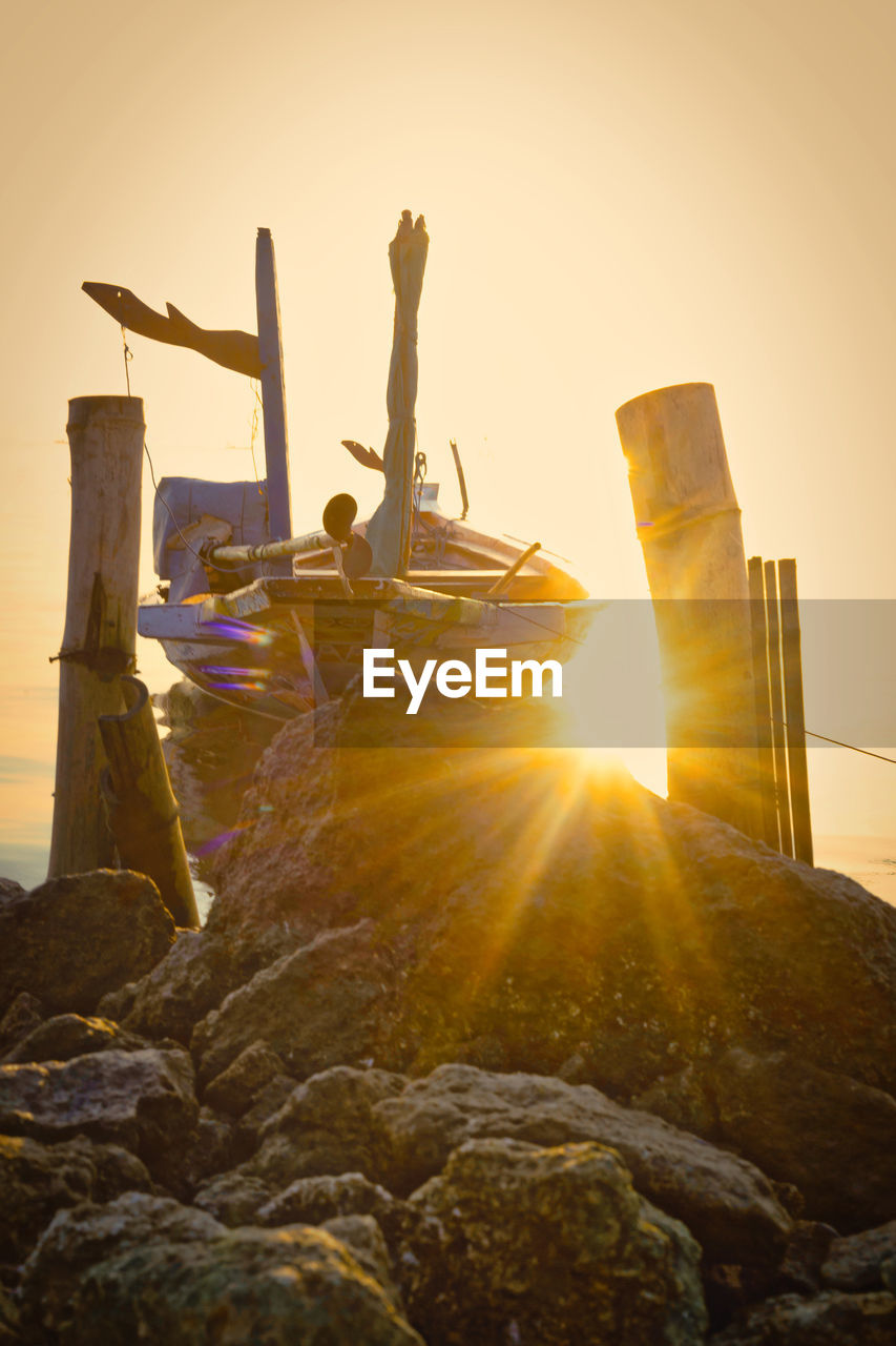 Sun shining through rocks and boat 