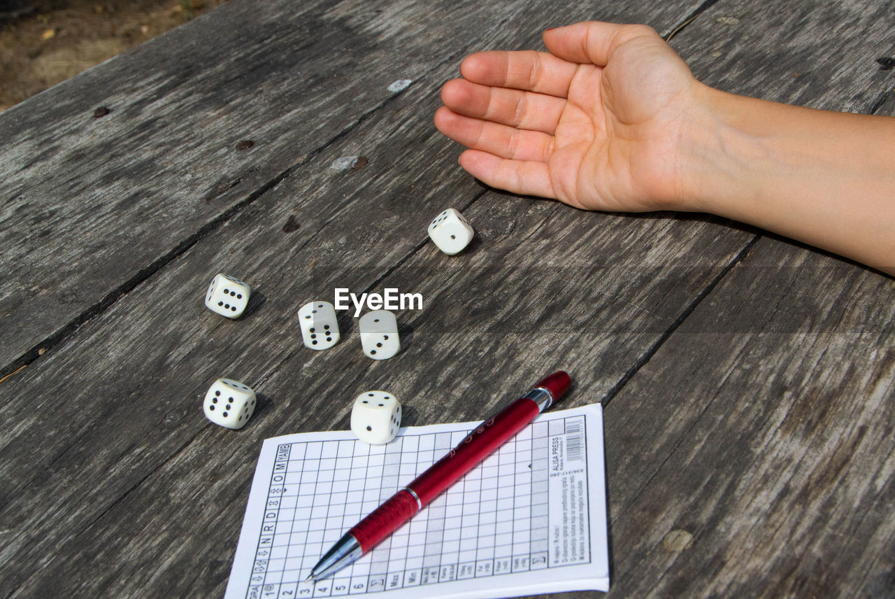 HIGH ANGLE VIEW OF HAND PLAYING ON TABLE