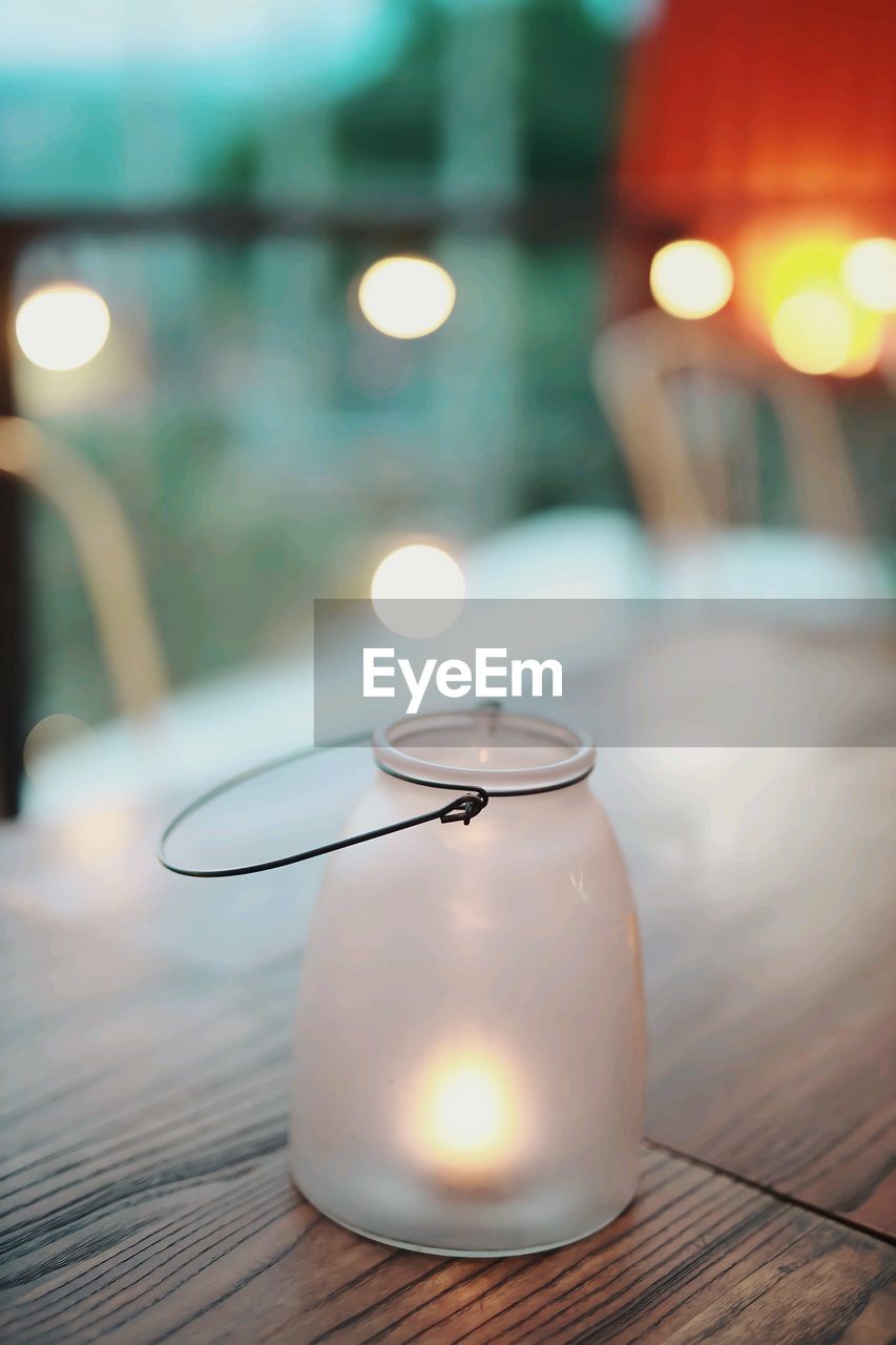 Close-up of illuminated light bulb on table