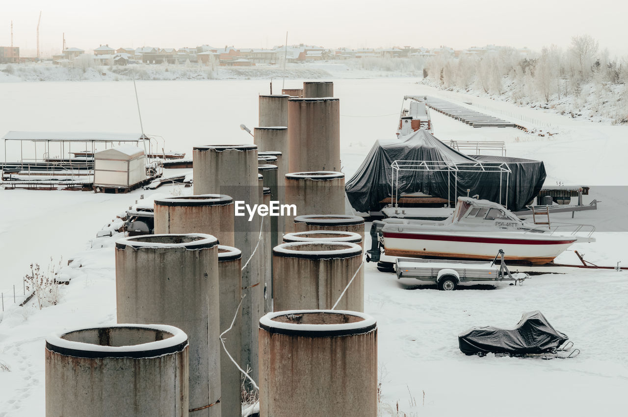 SAILBOATS MOORED ON FROZEN PIER AT HARBOR