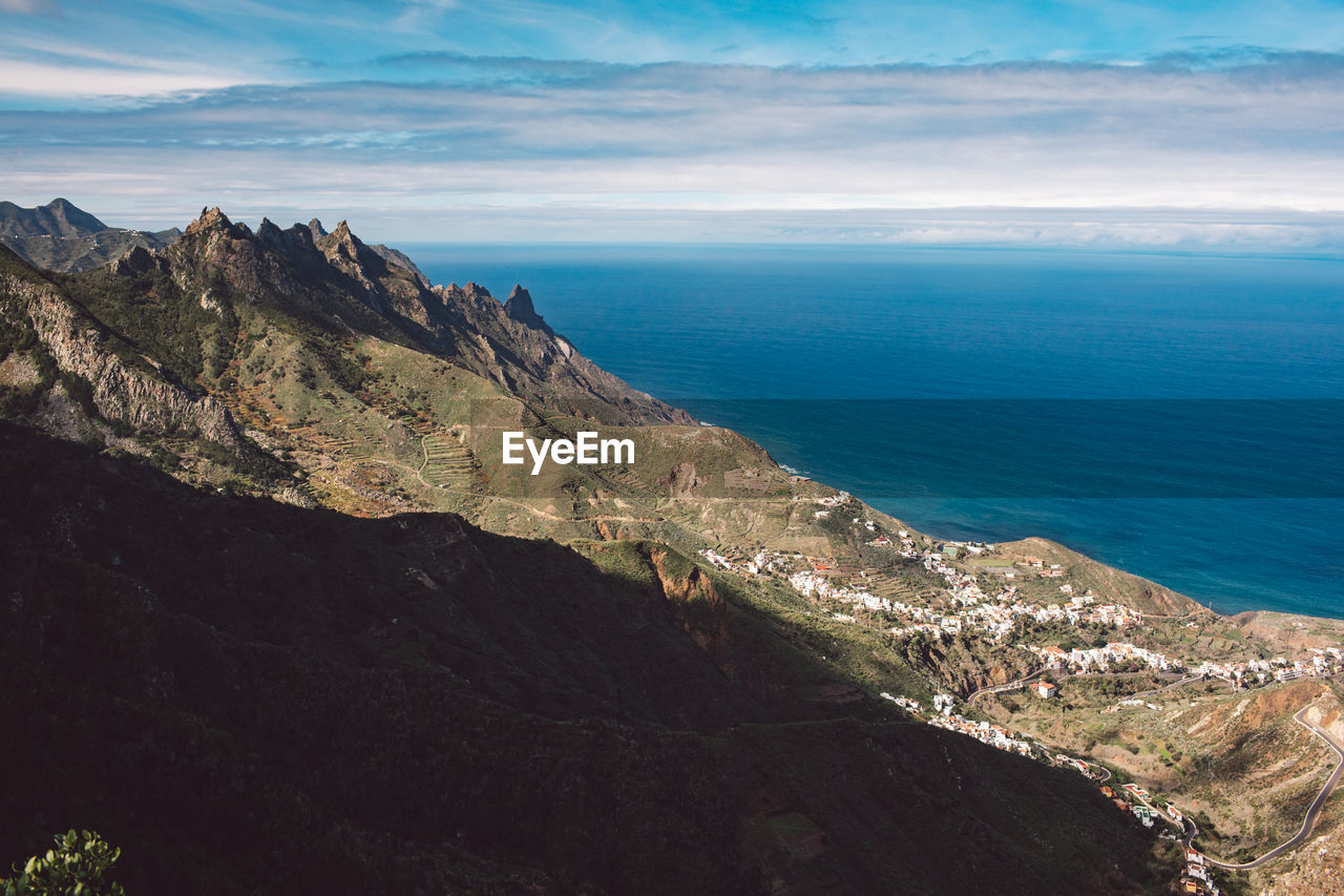 Scenic view of sea and mountains against sky