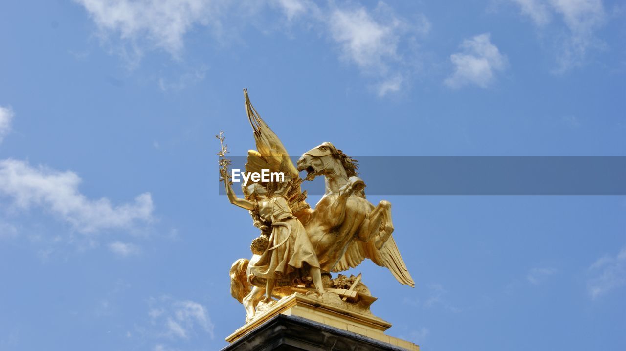 LOW ANGLE VIEW OF ANGEL STATUE AGAINST BLUE SKY