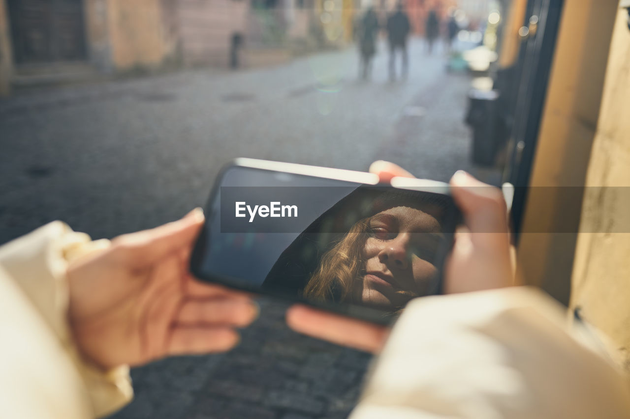 Young woman having video call, talking remotely, taking selfie photo holding smartphone