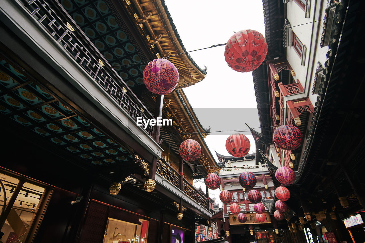 LOW ANGLE VIEW OF LANTERNS HANGING BY BUILDING