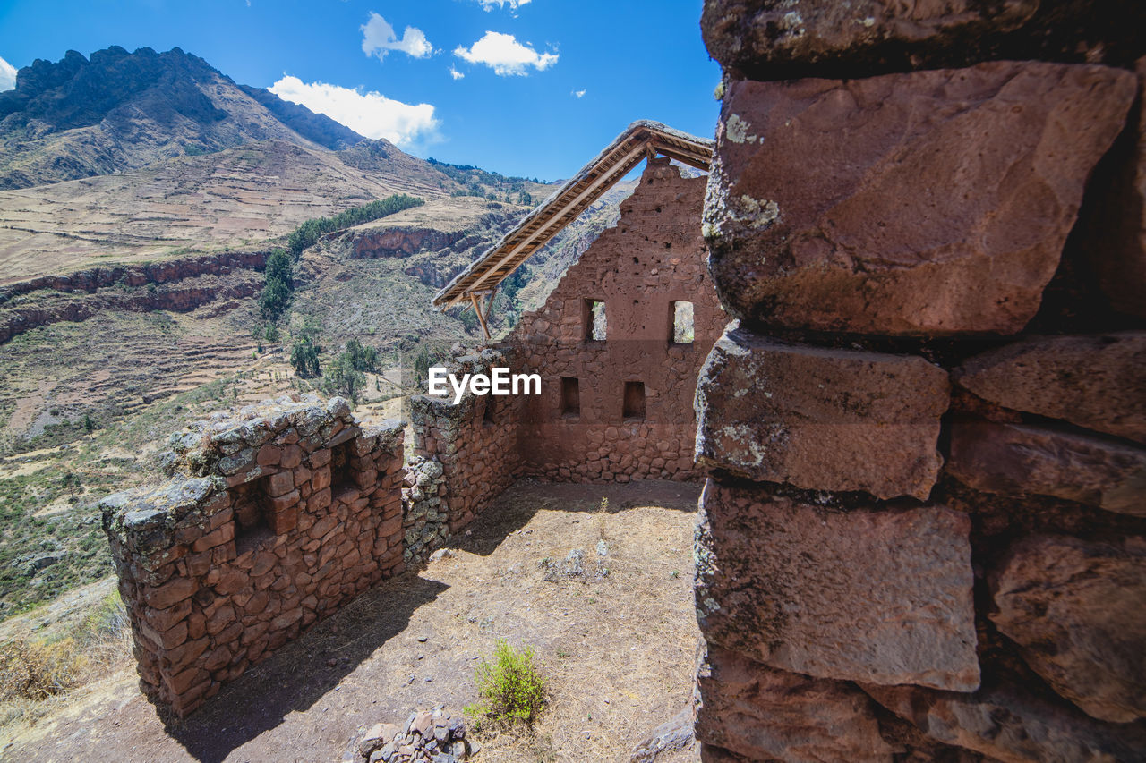 STONE WALL OF OLD BUILDING AGAINST MOUNTAIN