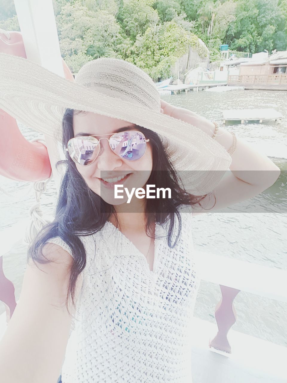 Portrait of smiling mid adult woman wearing sunglasses and hat