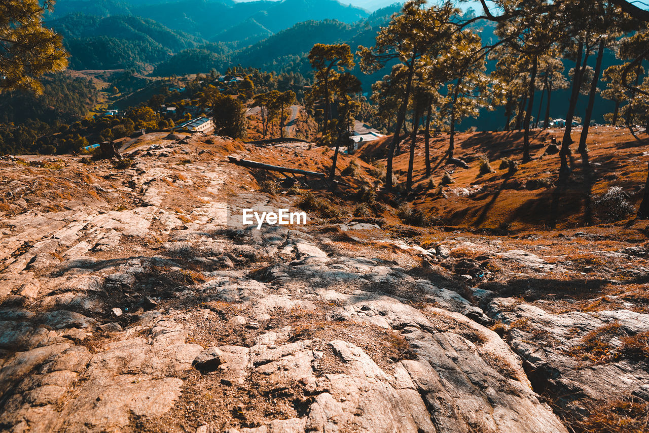 ROCK FORMATIONS ON LANDSCAPE AGAINST MOUNTAIN