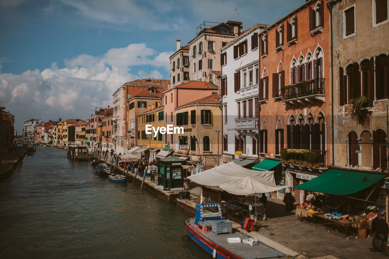 Boats in canal amidst buildings in city