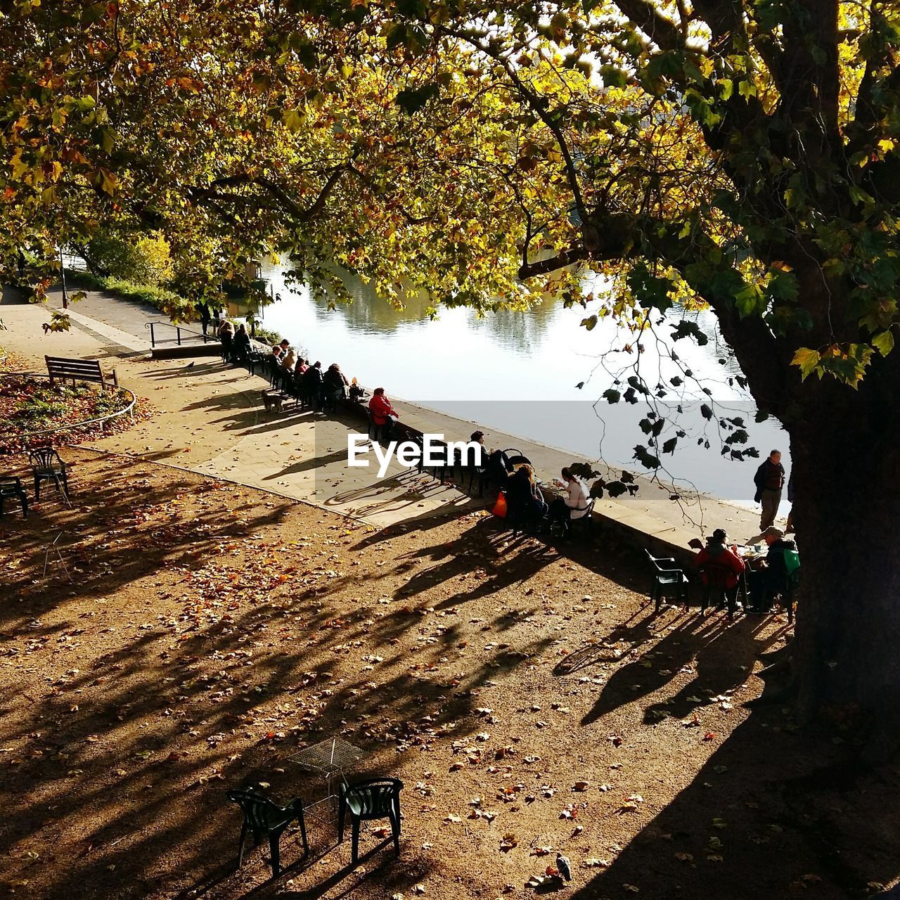 PEOPLE IN PARK BY WATER AGAINST SKY