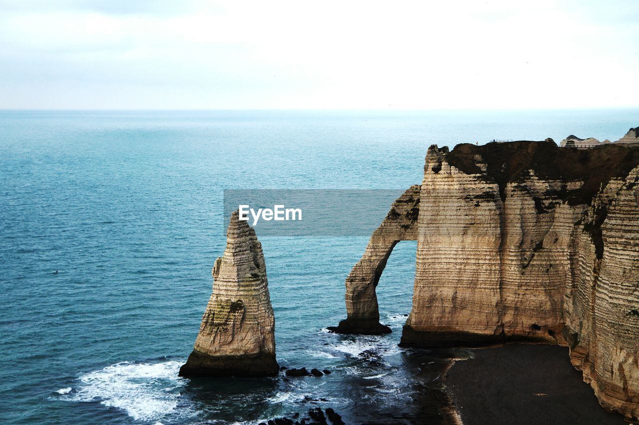 Scenic view of rock formation in sea against sky