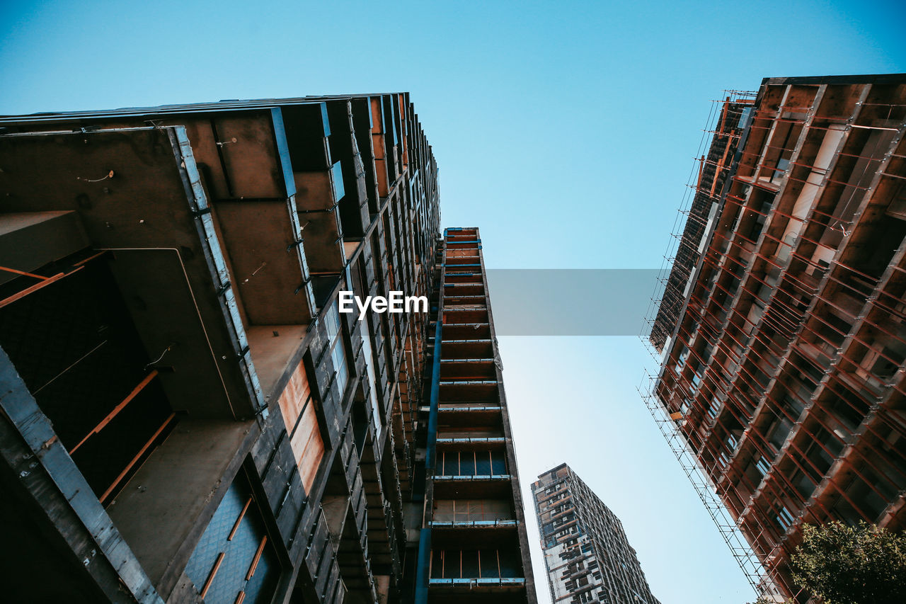 Low angle view of destroyed buildings against clear sky