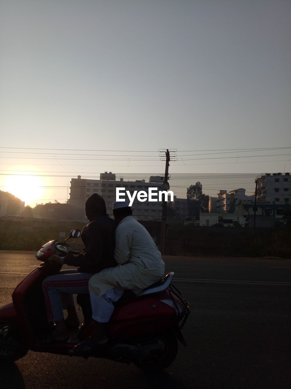 PEOPLE SITTING IN CITY AGAINST SKY