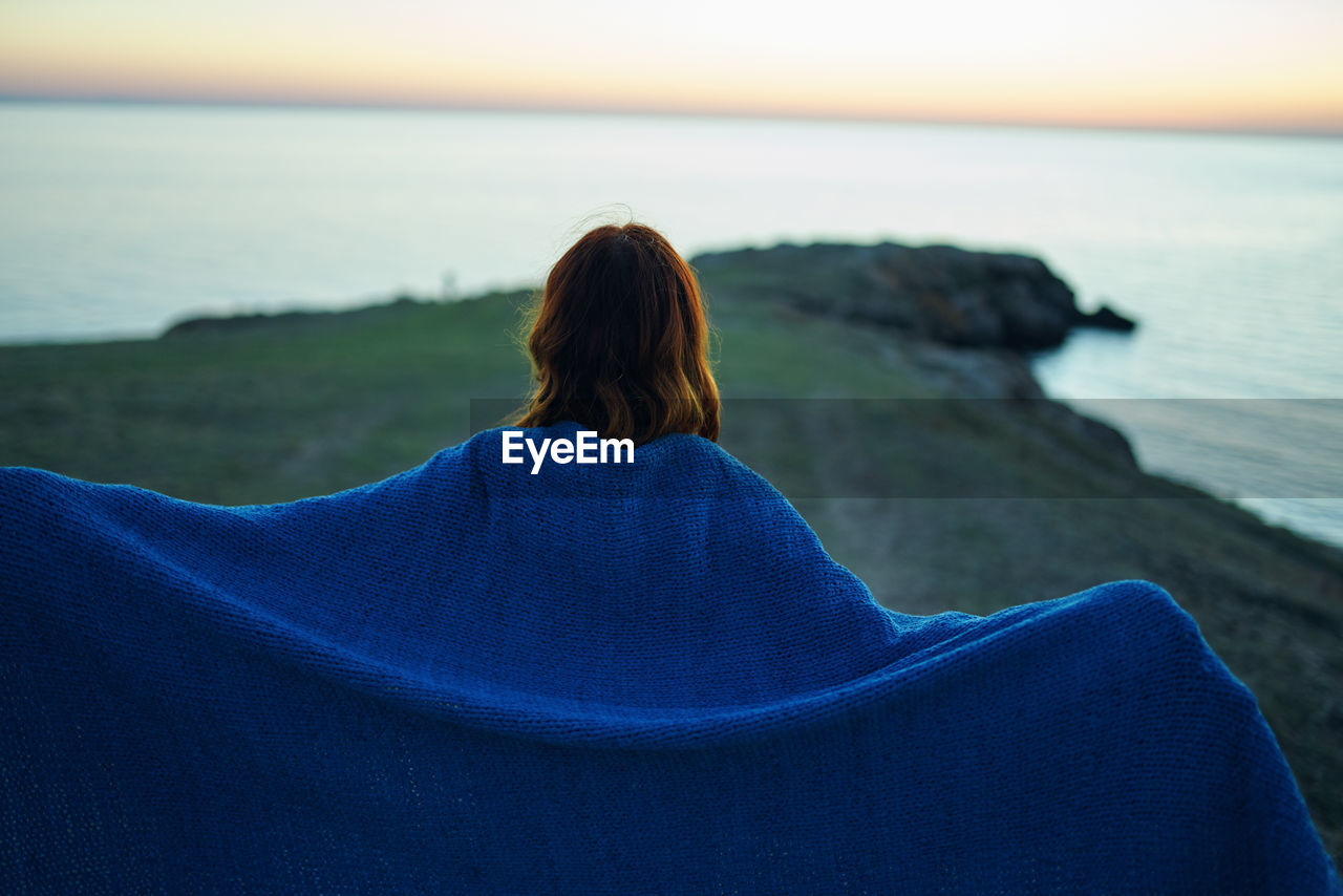 Rear view of woman relaxing on beach