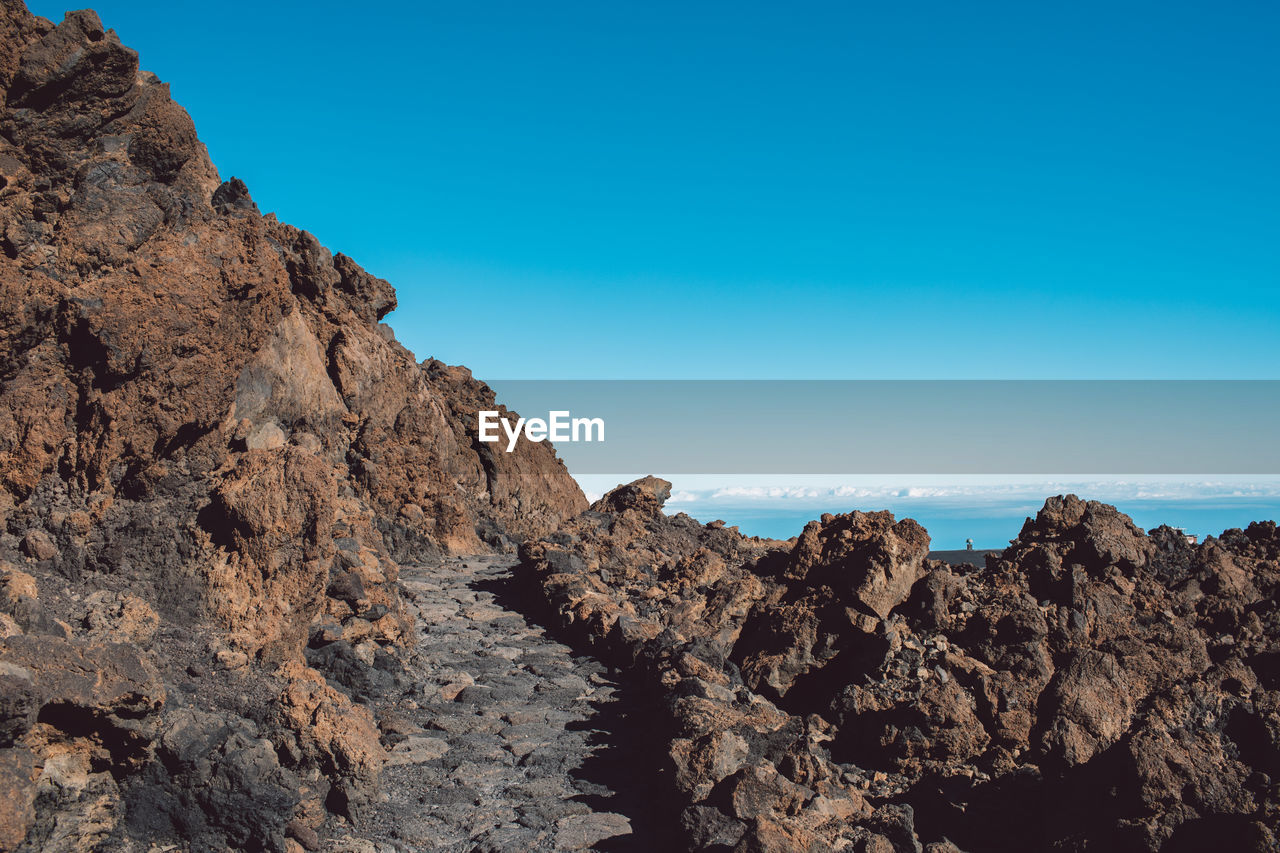 Scenic view of rocky mountains against clear blue sky