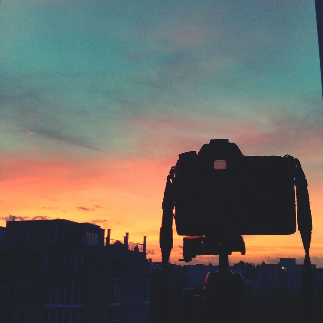 Camera capturing sunset over city