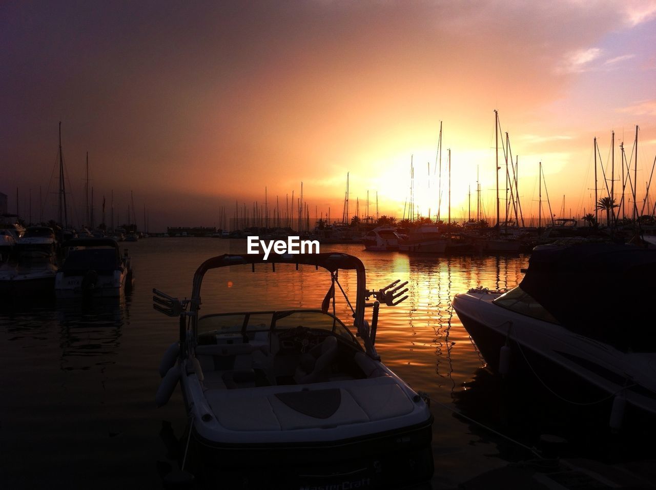 SAILBOATS MOORED AT SUNSET