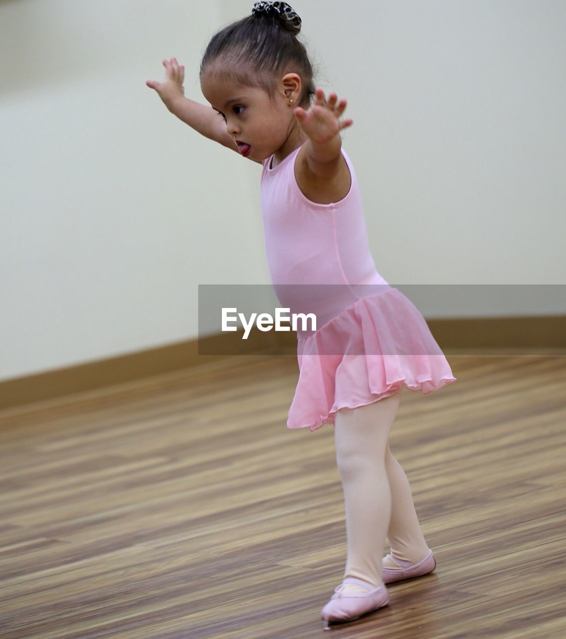 Girl with arms outstretched standing in dance studio